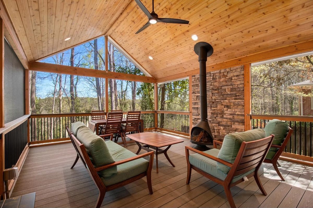 screened in porch with patio furniture and a fireplace